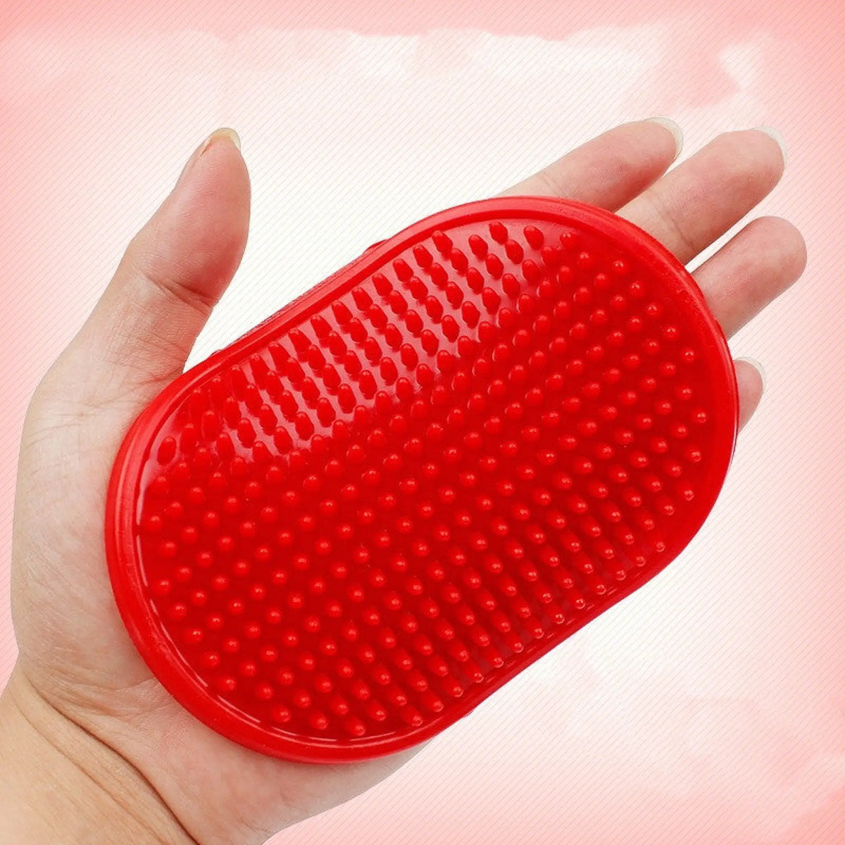 Red rubber pet bath massage brush with dense nubs held in a hand