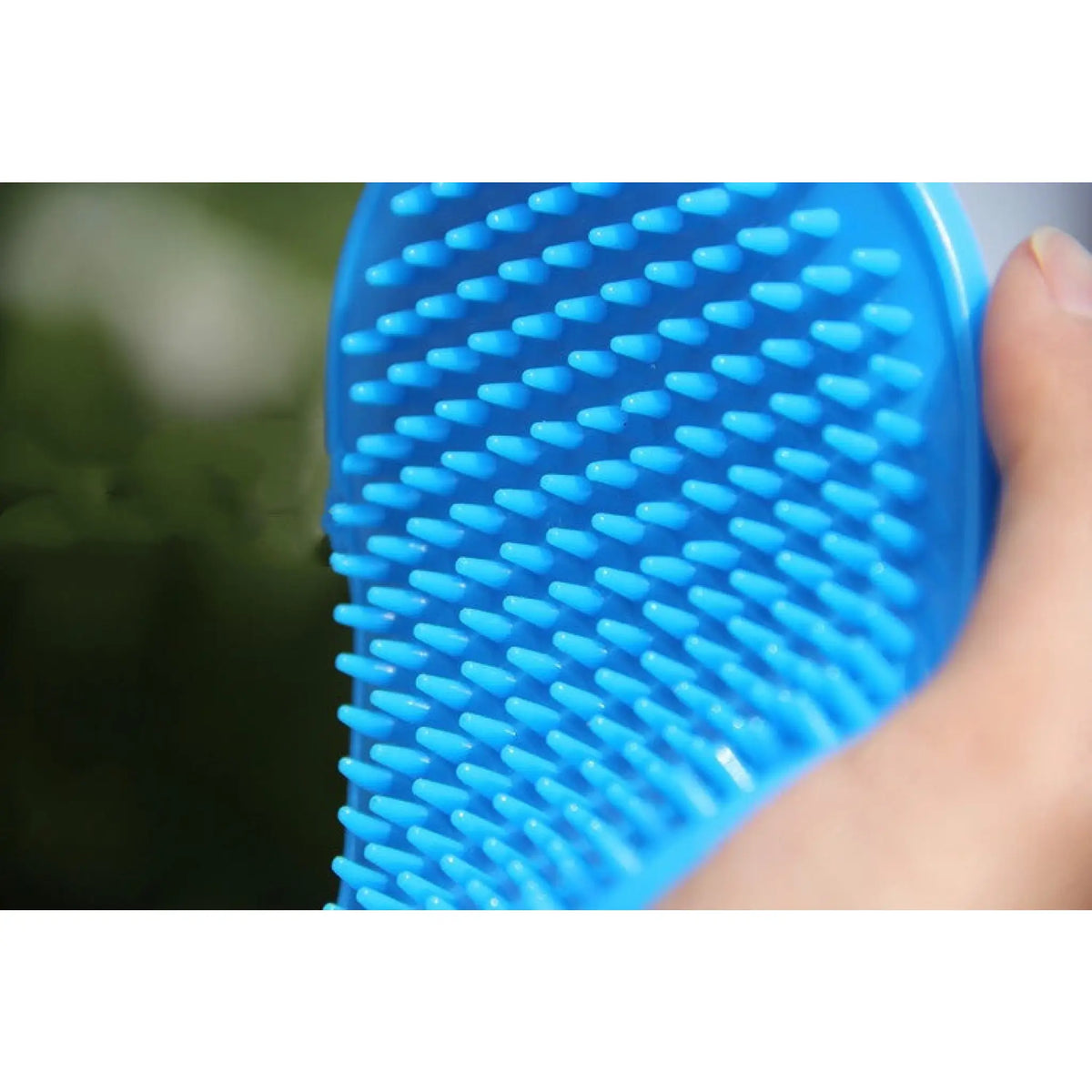 Close-up of soft blue rubber massaging nubs on a pet bath brush
