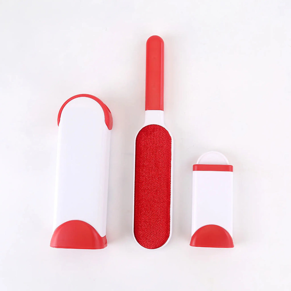 Red pet hair remover brush with fabric pad beside its self-cleaning base and mini base