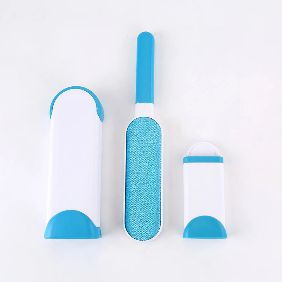 Sky blue pet hair remover brush with fabric pad beside its self-cleaning base and mini base