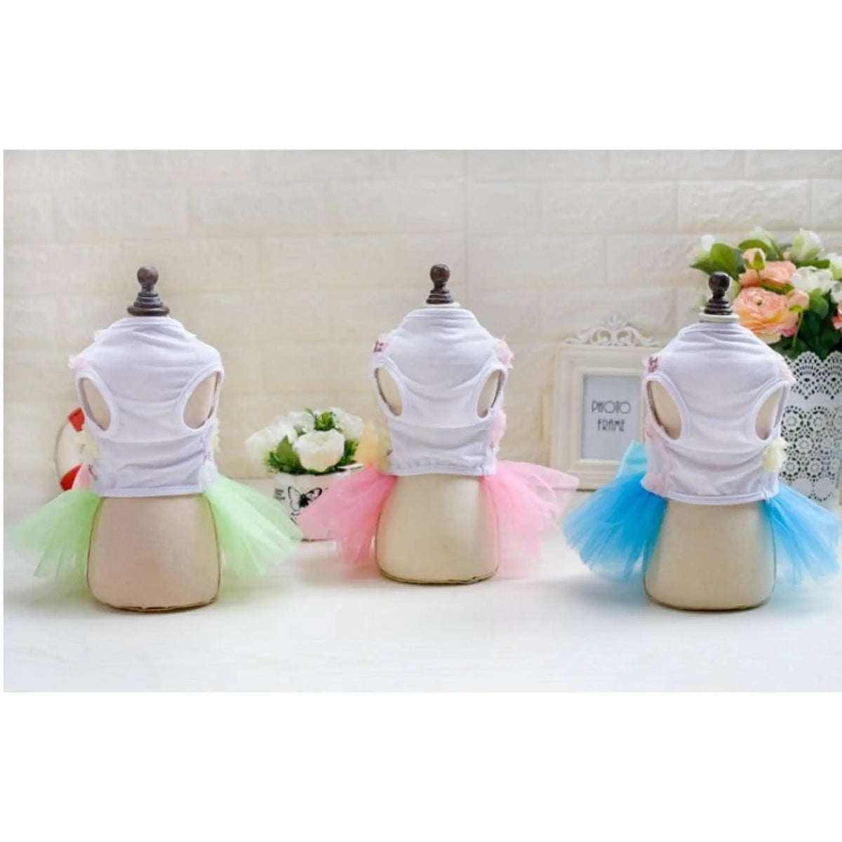 Back view of green, pink and blue tutu dog dresses on mannequins
