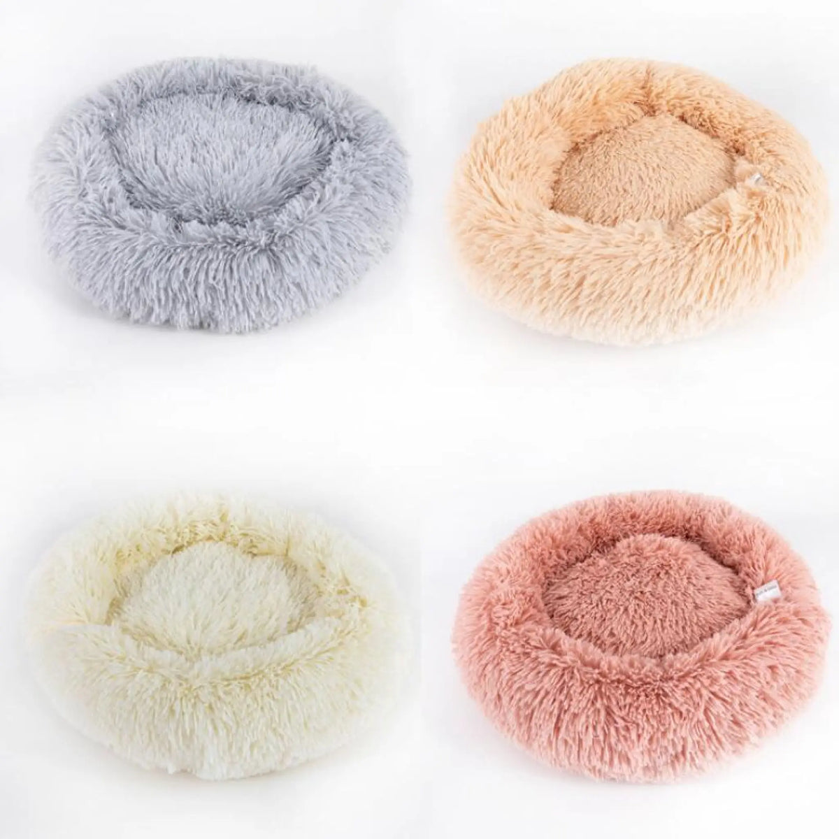 Four plush donut pet beds in gray, peach, cream and dusty rose